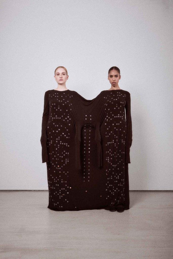 due modelle su un set inserite in un vestito nero da gemelle