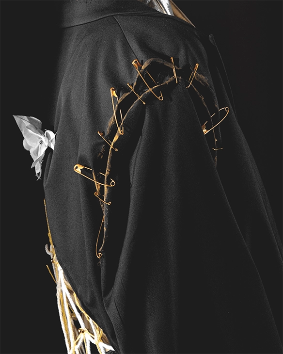 Detail of a jacket with golden pins and stitches.
