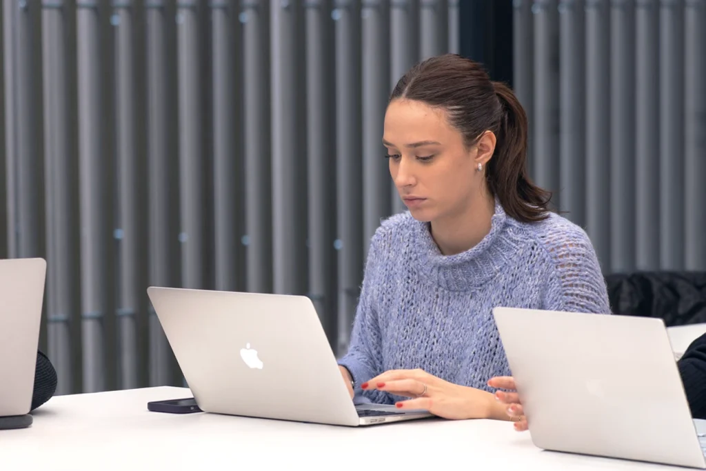 Studentessa prende appunti al computer.