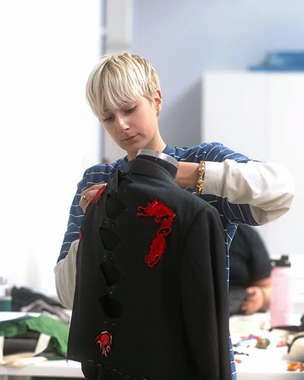 Student working on a garment with needle and thread.