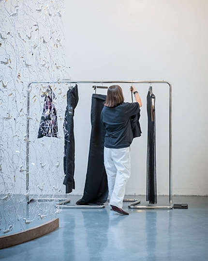 Student arranges her clothes on the clothes hanger.
