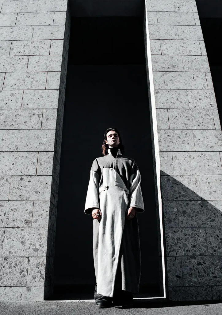 Model posing wearing grey coat made by students.