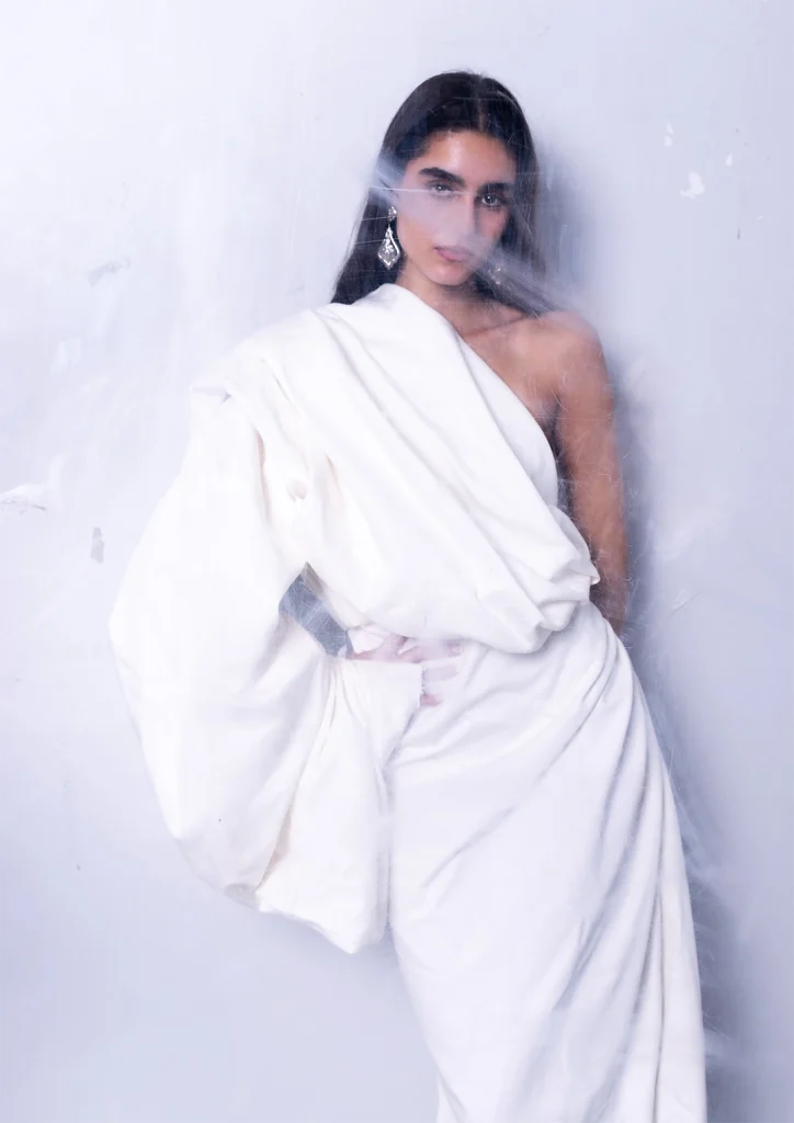 Model poses in the white dress made by the students.