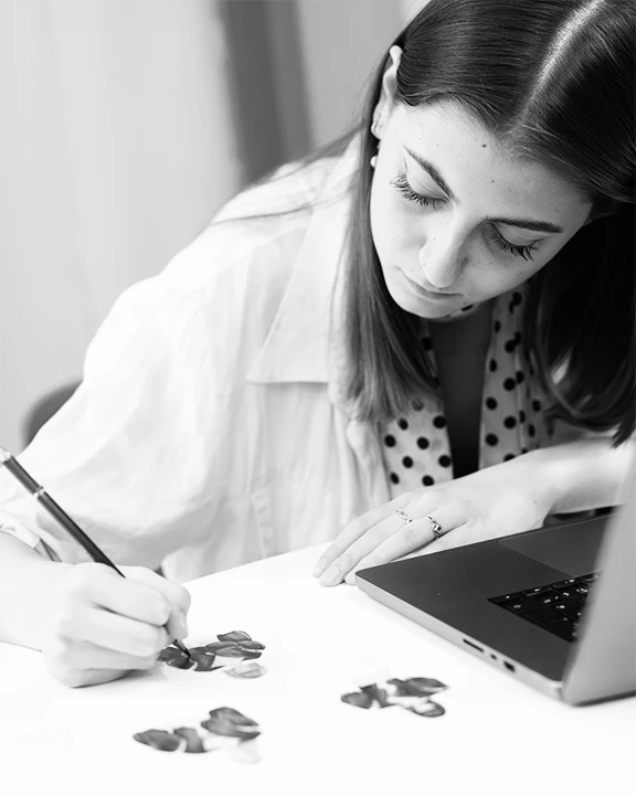 Studentessa disegna a mano bozze dei suoi abiti.